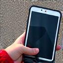 Close-up on a hand holding a tablet, documenting vehicle damage at an accident scene for insurance purposes.