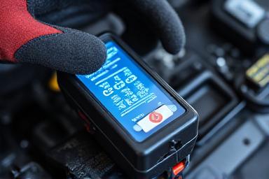 Car battery being tested in a cold garage environment.